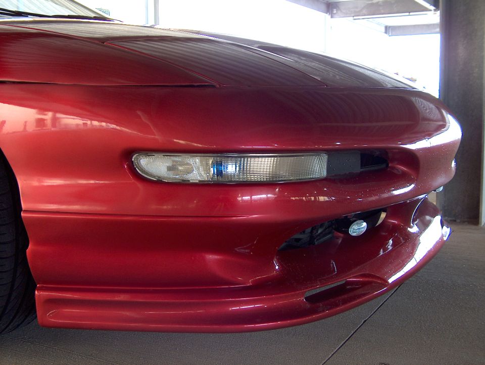 Front corner of red Ford Probe with body kit and projector-style headlight