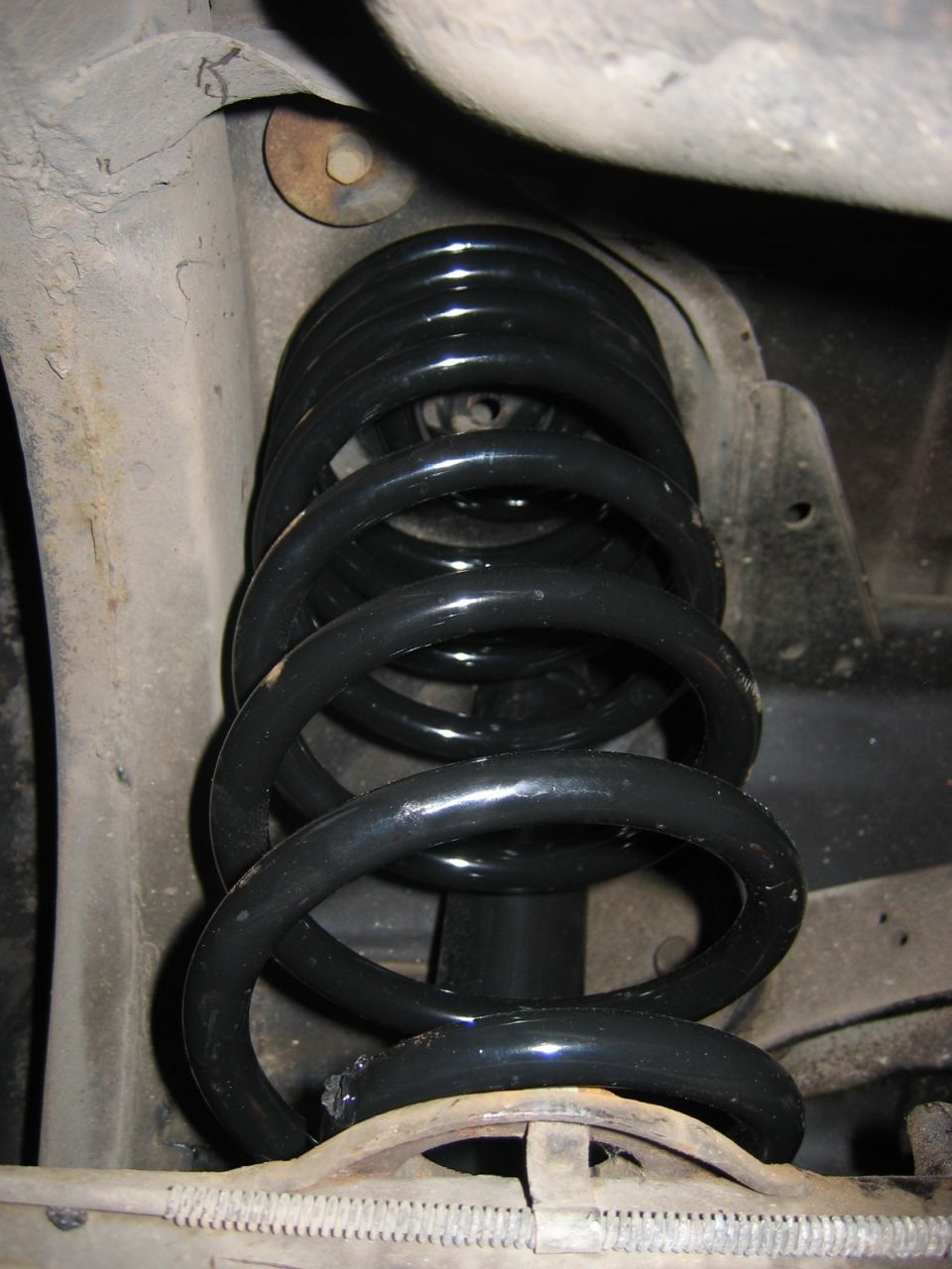 Black coil spring and shock absorber assembly on a vehicle's undercarriage