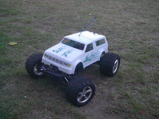 White remote control monster truck with green flame decals and large tires