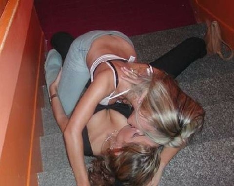 1986 Ford Bronco - A party snapshot of two people lying together and kissing on a carpeted staircase beside an orange-painted wall. No vehicle or vehicle part…