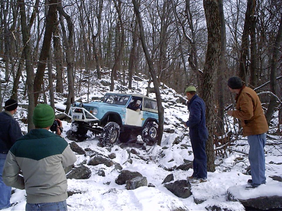 Light blue off-road vehicle with roll cage navigating snowy terrain