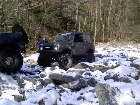 1989 Ford F-350 - A Suzuki Samurai navigates a rocky, snow-covered trail, with another vehicle partially visible on the left.