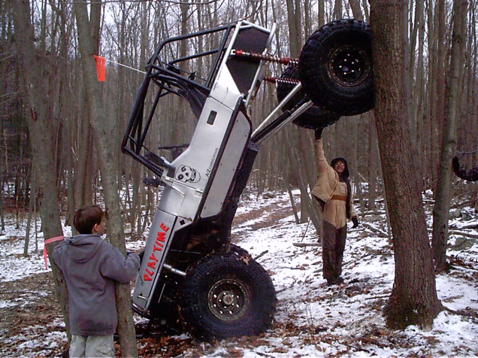 Off-road vehicle tilted against trees, with "PLAY TIME" visible on its side