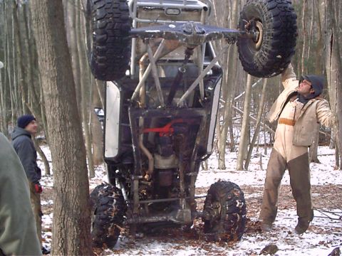 1989 Ford F-350 - An off-road buggy is seen upside down in a snowy forest with onlookers.