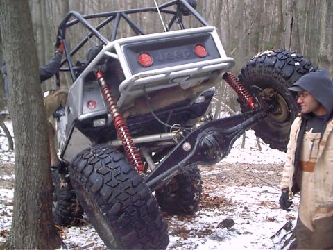 1989 Ford F-350 - This heavily modified Jeep appears to be stuck in a wooded area with snow on the ground.