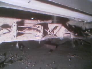 1986 Ford Bronco - Close-up view of the vehicle's undercarriage, focusing on the suspension and frame structure.