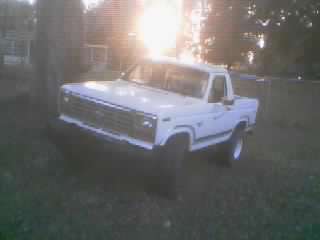 1986 Ford Bronco - This 1980s Ford pickup truck is seen from a 3/4 front angle in a grassy area.