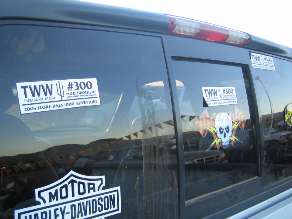Dark SUV window with TWW #300 Baja 1000 and Harley-Davidson stickers