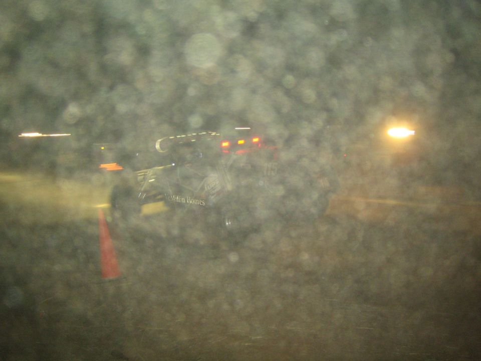 Blurry night shot of an off-road race vehicle behind a rain-spotted window