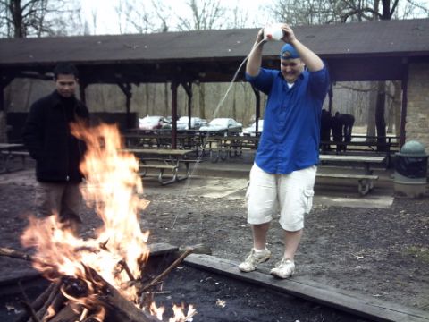 1995 Ford Probe - Two men are gathered around a campfire in an outdoor park setting.