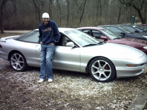 1995 Ford Probe - Man poses with his silver 1995 Ford Probe at an outdoor gathering.