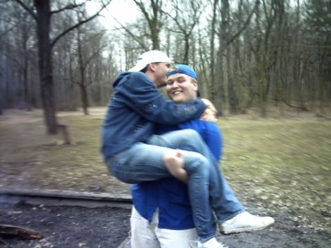 1995 Ford Probe - Two people embrace outdoors in a wooded area during daytime.