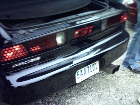 1995 Ford Probe - The rear of a black 1995 Ford Probe GT is visible, showing its distinctive taillights and exhaust.