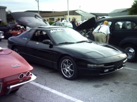 1995 Ford Probe - A black 1995 Ford Probe is parked at an outdoor car show, with its hatch open.