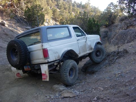 1987 Ford Bronco - This 1987 Ford Bronco is navigating a challenging off-road course on a dirt and rock path.