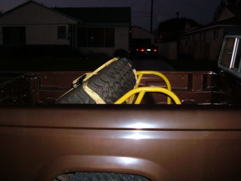 1985 Ford Ranger - Spare tire and roll bar visible in the bed of a brown pickup truck at dusk.