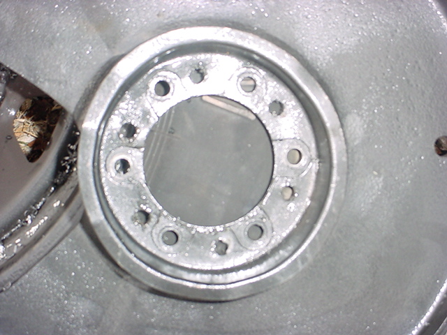 Close-up of silver-painted steel wheel hub area with eight lug holes and open center bore