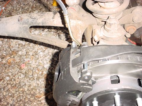 1983 Ford Bronco - Vehicle brake caliper and rotor assembly detail, showing suspension parts and brake lines.