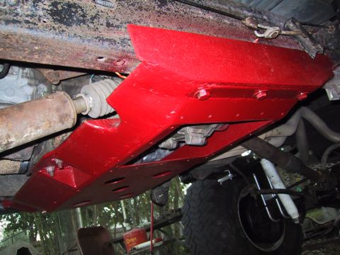 1990 Ford Bronco - Red skid plate installed on the underside of a vehicle, covering drivetrain components.