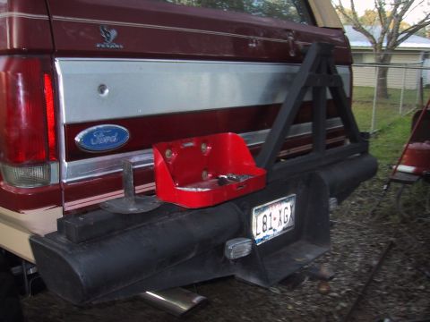 1990 Ford Bronco - Rear view of a red Ford Bronco showing its bumper, spare tire carrier, and a toolbox attached.
