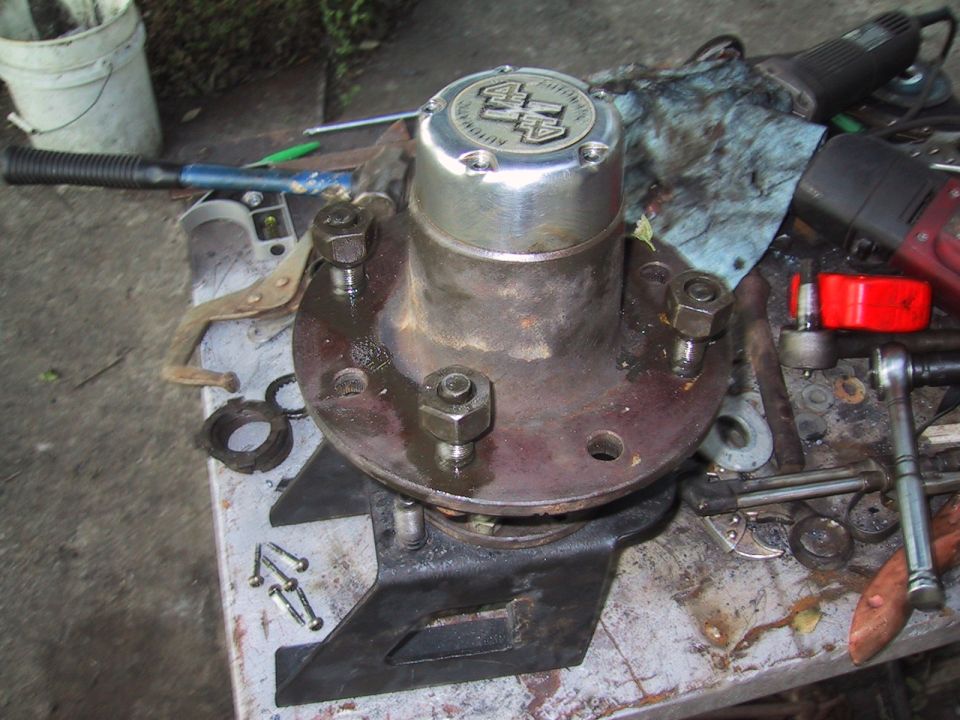 Close-up of a 4x4 automatic locking hub assembly on a workbench with tools