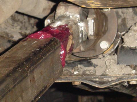 1989 Ford Bronco - Close-up of a driveshaft u-joint with red grease applied.