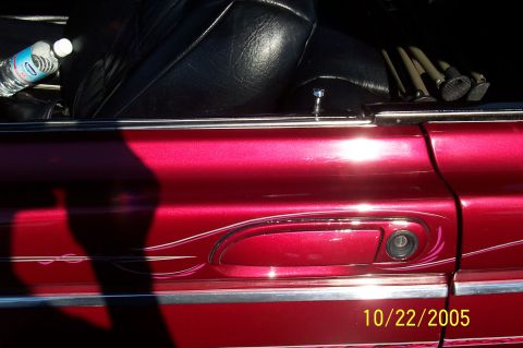 1969 Ford Ranchero - A water bottle sits on the seat of a red pickup truck with custom paint and pinstriping.