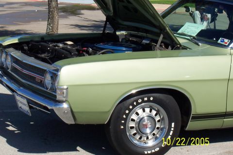 1969 Ford Ranchero - A light green 1969 Ford Ranchero GT is displayed with its hood open, revealing the engine and a prominent GT badge on the grille.