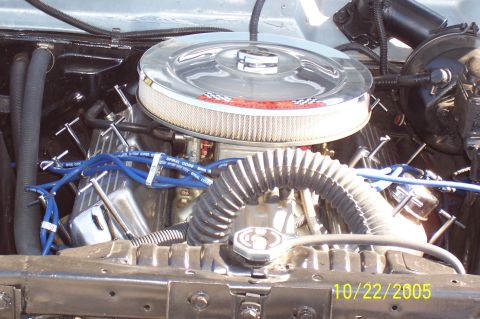 1969 Ford Ranchero - Close-up of a vehicle's engine bay, a chrome air cleaner and blue spark plug wires.