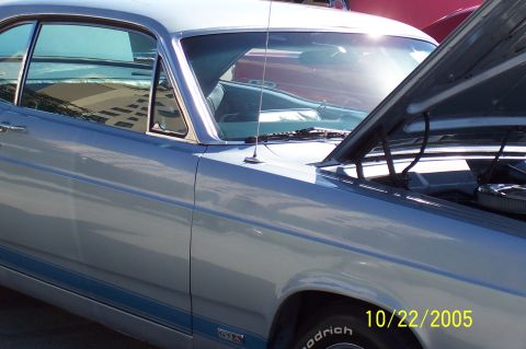 1969 Ford Ranchero - A light blue 1969 Ford Ranchero is shown with its hood up, revealing the engine and interior. A blue stripe runs along its side.