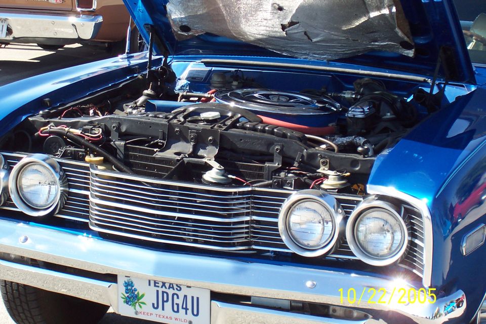 Open hood of blue muscle car showing V8 with chrome air cleaner and Texas JPG4U plate