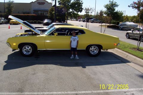 1969 Ford Ranchero - A yellow 1969 Ford Ranchero is parked with its hood open, a child stands beside it.