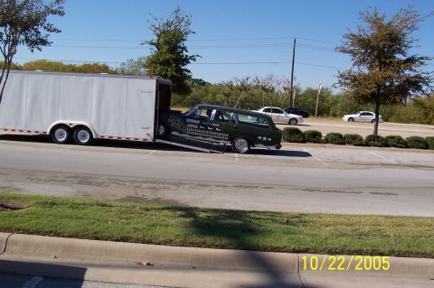 1969 Ford Ranchero - A dark green station wagon with custom graphics is being loaded into a white trailer.