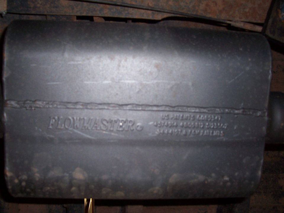 Flowmaster muffler mounted under a vehicle with stamped patent text on the case