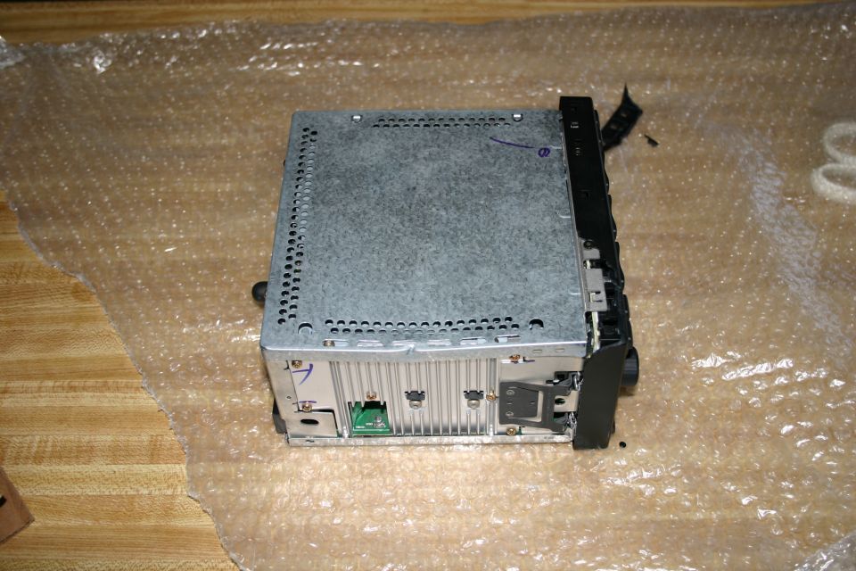 Car stereo with metal casing and black faceplate, viewed from rear