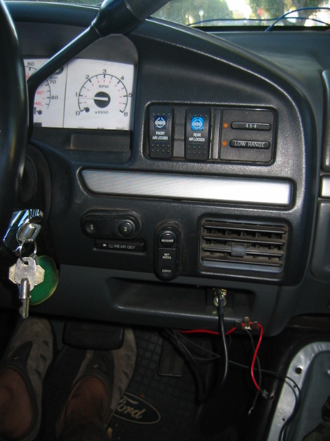 1992 Ford Bronco - The dashboard of a truck features auxiliary switches for off-road functions and a set of keys in the ignition.