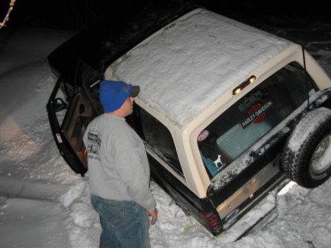 1992 Ford Bronco - A 1992 Ford Bronco is stuck in the snow with its driver's side door open.