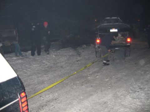 1992 Ford Bronco - Two vehicles and several people are in a snowy area at night, with a yellow strap connecting them.