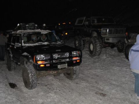 1992 Ford Bronco - Two SUVs are parked in the snow at night, with one appearing to be a Jeep Cherokee and the other a Ford Bronco.
