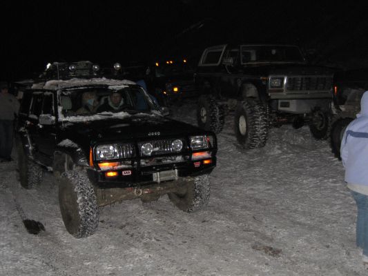 Black Jeep Cherokee and Ford Bronco in snow at night
