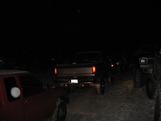1992 Ford Bronco and other trucks parked at night