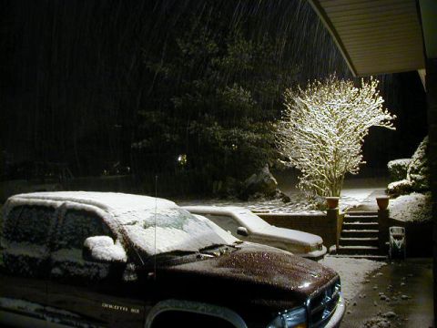 1994 Ford Probe - A snowy scene depicts two vehicles parked in front of a house with snow falling.