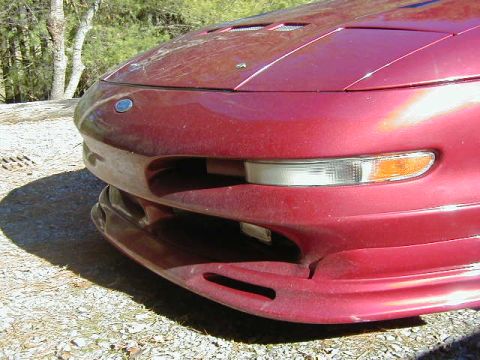1994 Ford Probe - The front bumper and headlights of a red Ford Probe are visible in this close-up shot.