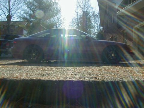 1994 Ford Probe - A red 1994 Ford Probe is parked outside a brick building on a sunny day.