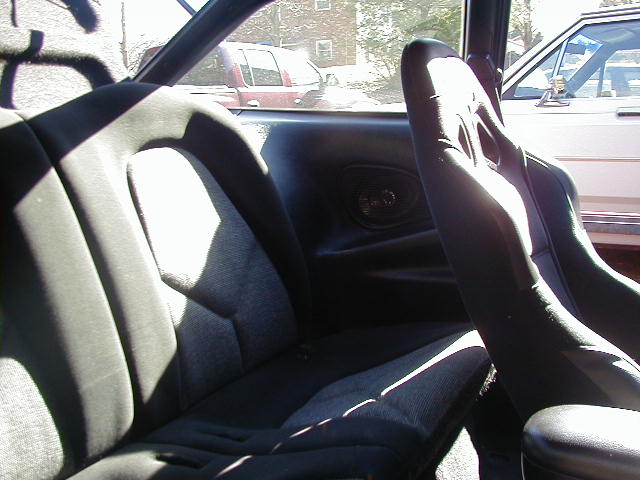 Interior view of car with racing seats and a red pickup truck visible outside