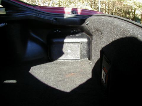 1994 Ford Probe - The interior of a car trunk shows a black speaker enclosure and carpeted surfaces.