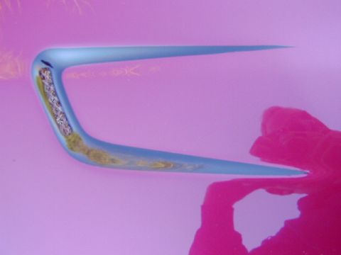 1994 Ford Probe - Close-up of a car door handle, showing its blue exterior and internal components against a pink backdrop.