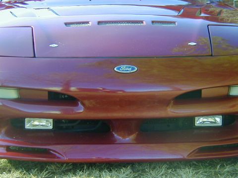1994 Ford Probe - Front view of a red 1994 Ford Probe, its distinctive pop-up headlights and Ford emblem.