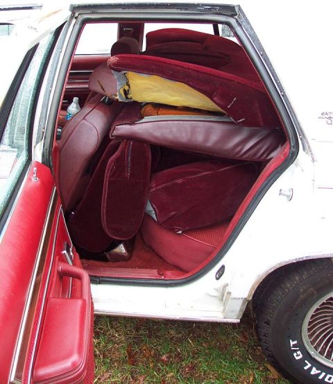 1985 Ford LTD Crown Victoria - The interior of a car is filled with removed seats, revealing the bare structure and floor.