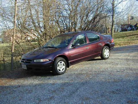 1994 Ford Probe - Maroon sedan parked on gravel with trees in the background. The car's body style suggests a mid-1990s model.